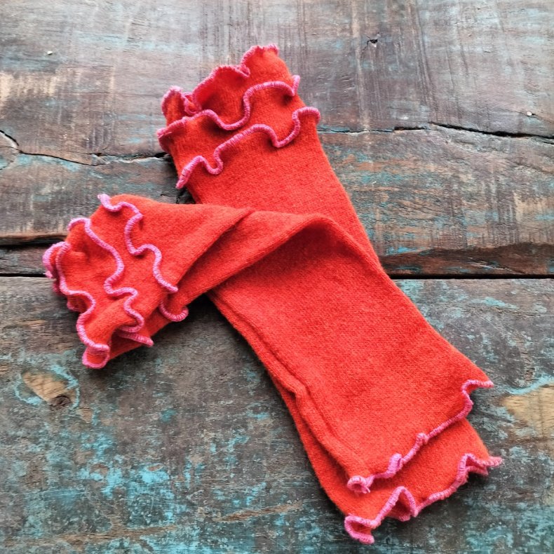 Pulsvarmer i orange med  lyser�de syninger